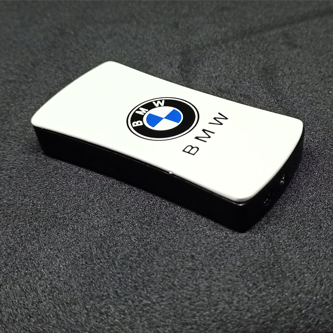 BMW logo on a white rectangular object against a dark background BMW Jet Flame Cigarette Lighter