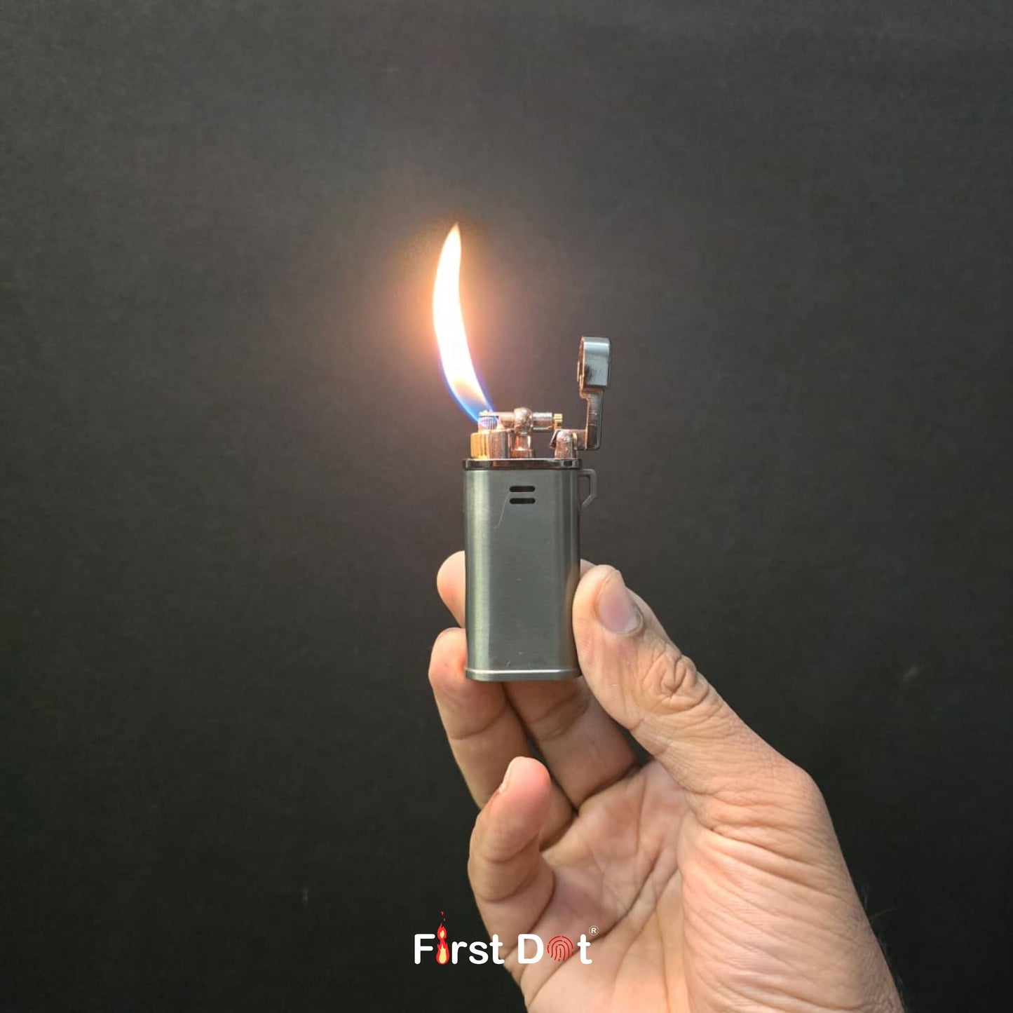 Hand holding a lit lighter against a dark background with 'First Dot' branding.