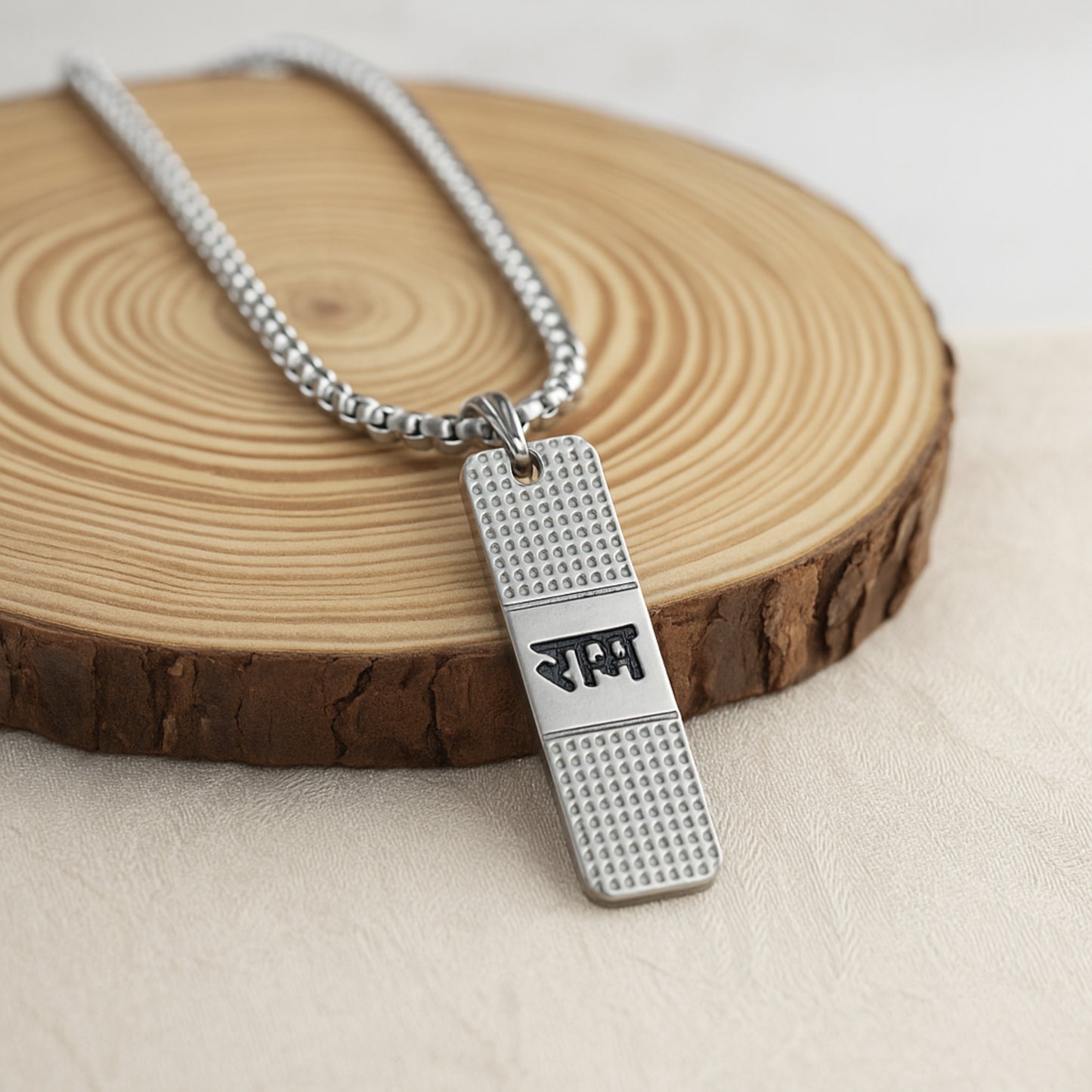 Silver necklace with a pendant on a wooden surface ShriRam NaamPendantLocketwithChain
