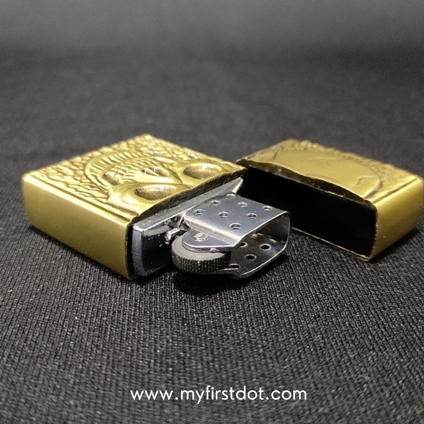 Gold lighter with intricate design on a dark background