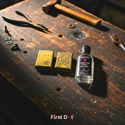 Lighter fuel bottle and gold lighter cases on a wooden surface with 'First Dot' branding.