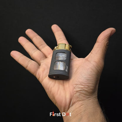 Hand holding a small black and gold device with 'First Dot' branding on a dark background
