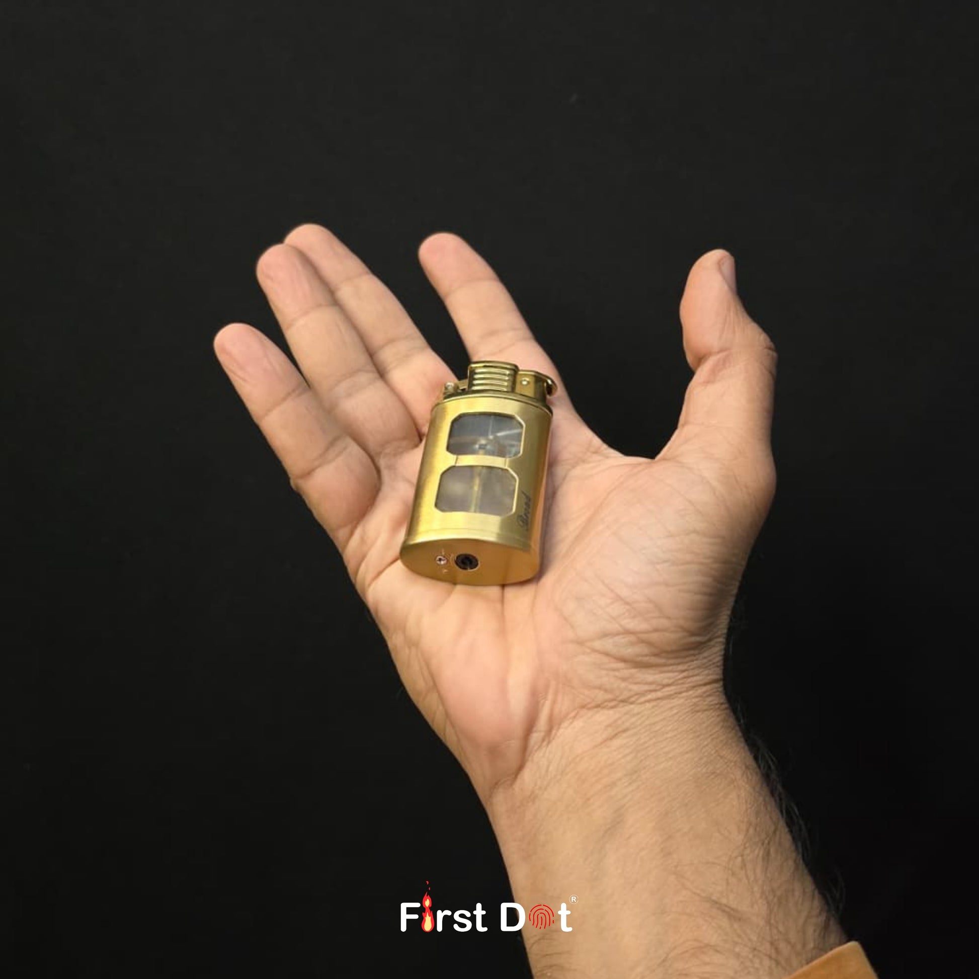 Hand holding a small gold object against a black background with 'First Dot' branding.