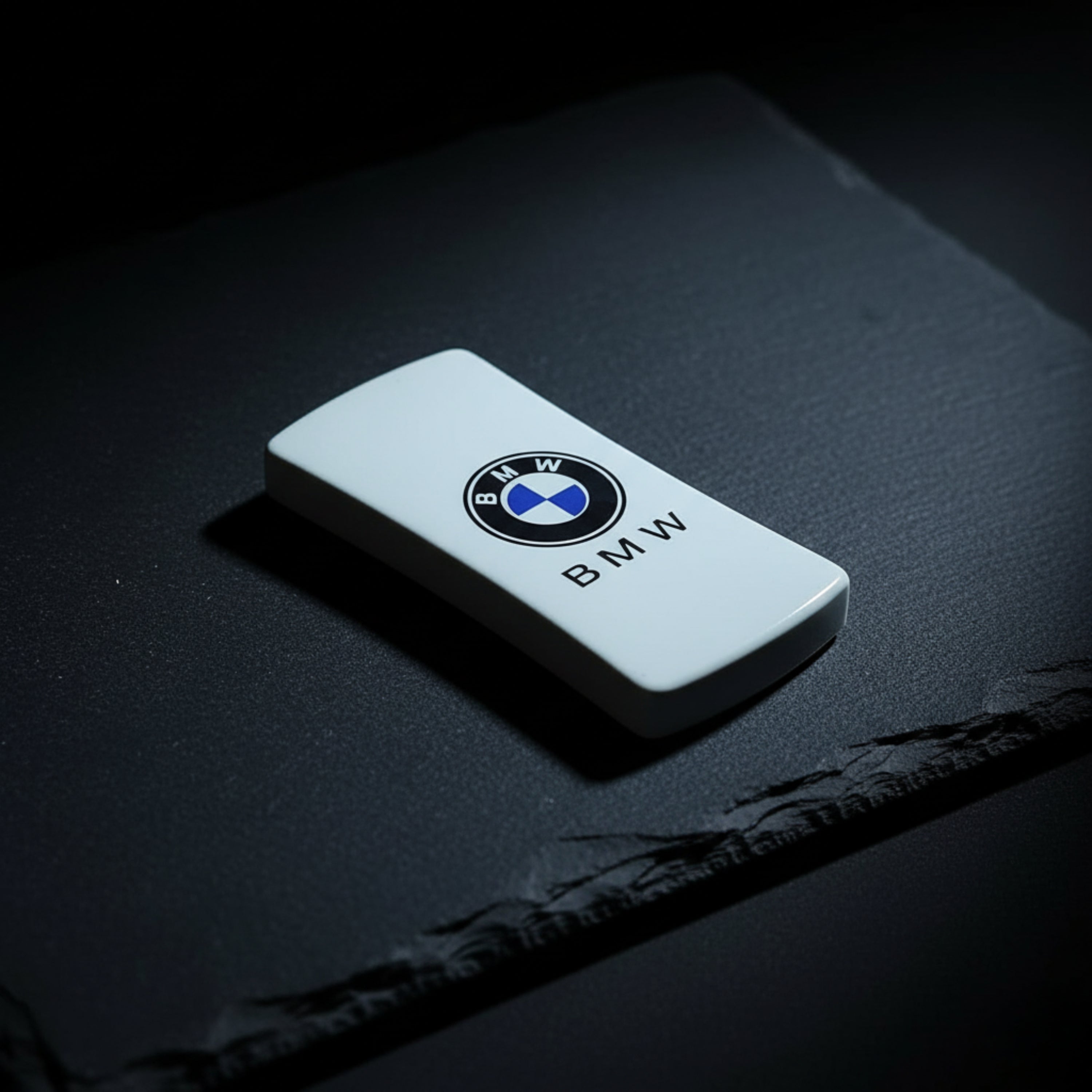 BMW key fob on a dark textured surface BMW Jet Flame Cigarette Lighter