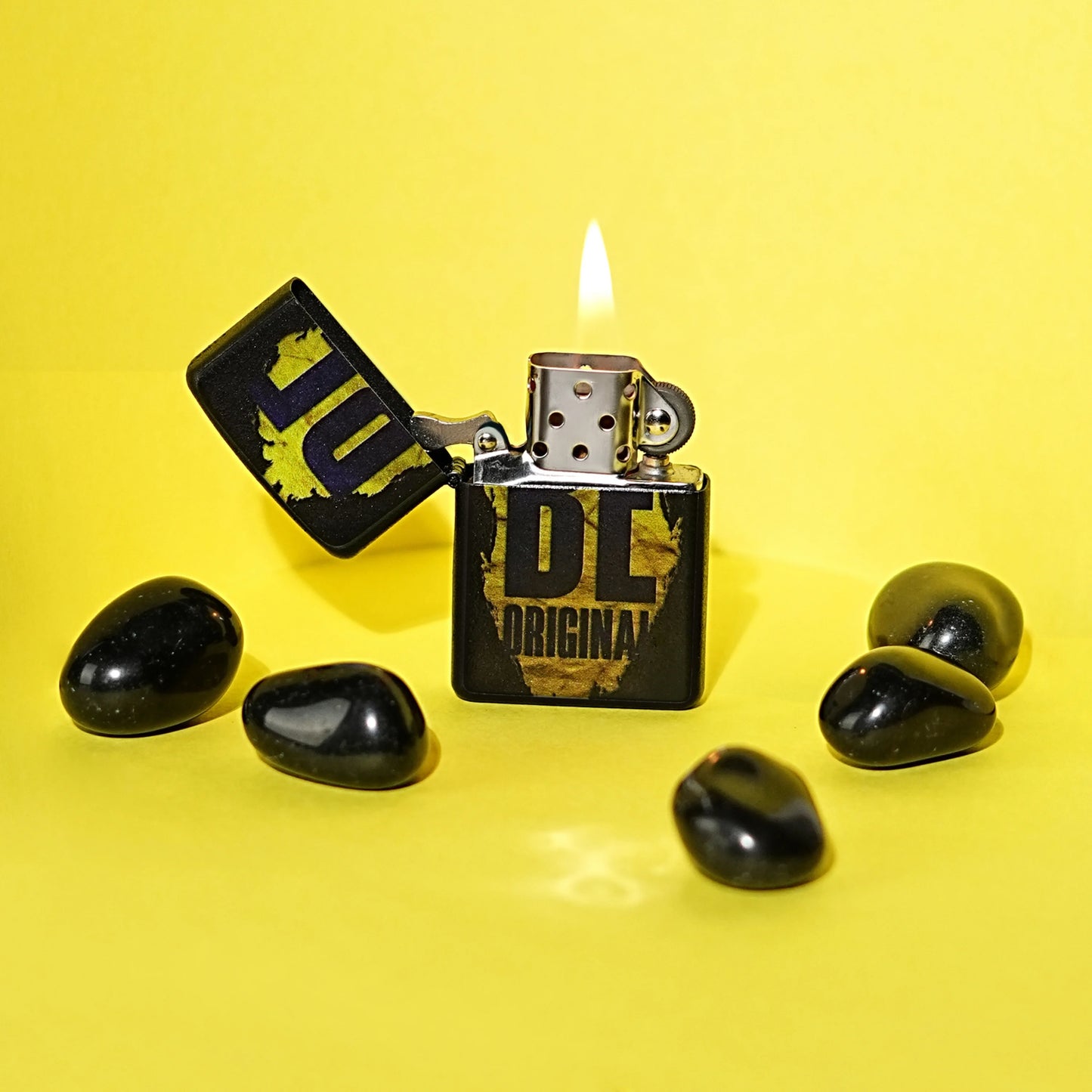 Black lighter with 'HUF' branding on a yellow background Be Original Premium Refillable Cigarette Lighter – powered by liquid fuel, strong flame, sleek design, and made to stand out with every spark.