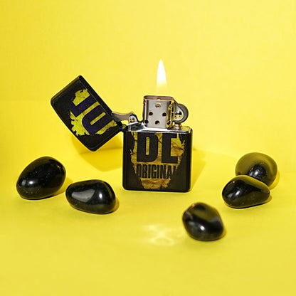 Black lighter with 'HUF' branding on a yellow background Be Original Premium Refillable Cigarette Lighter – powered by liquid fuel, strong flame, sleek design, and made to stand out with every spark.