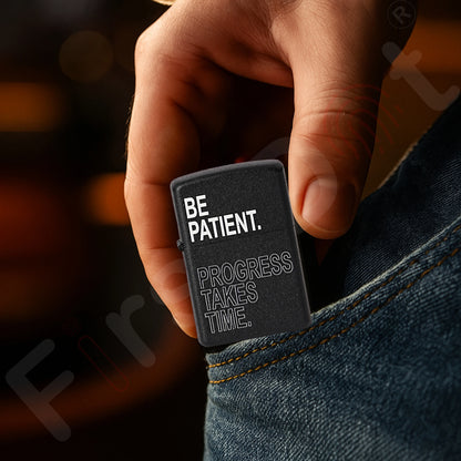Hand holding a black lighter with motivational text against a blurred background Be Patient Premium Refillable Cigarette Lighter