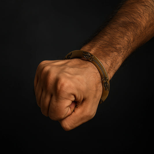 Hand wearing a gold bracelet on a black background महाकाल Brass Kada