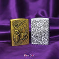 Two zippo lighters, one gold and one silver with intricate designs, on a purple fabric background. First Dot brand visible.
