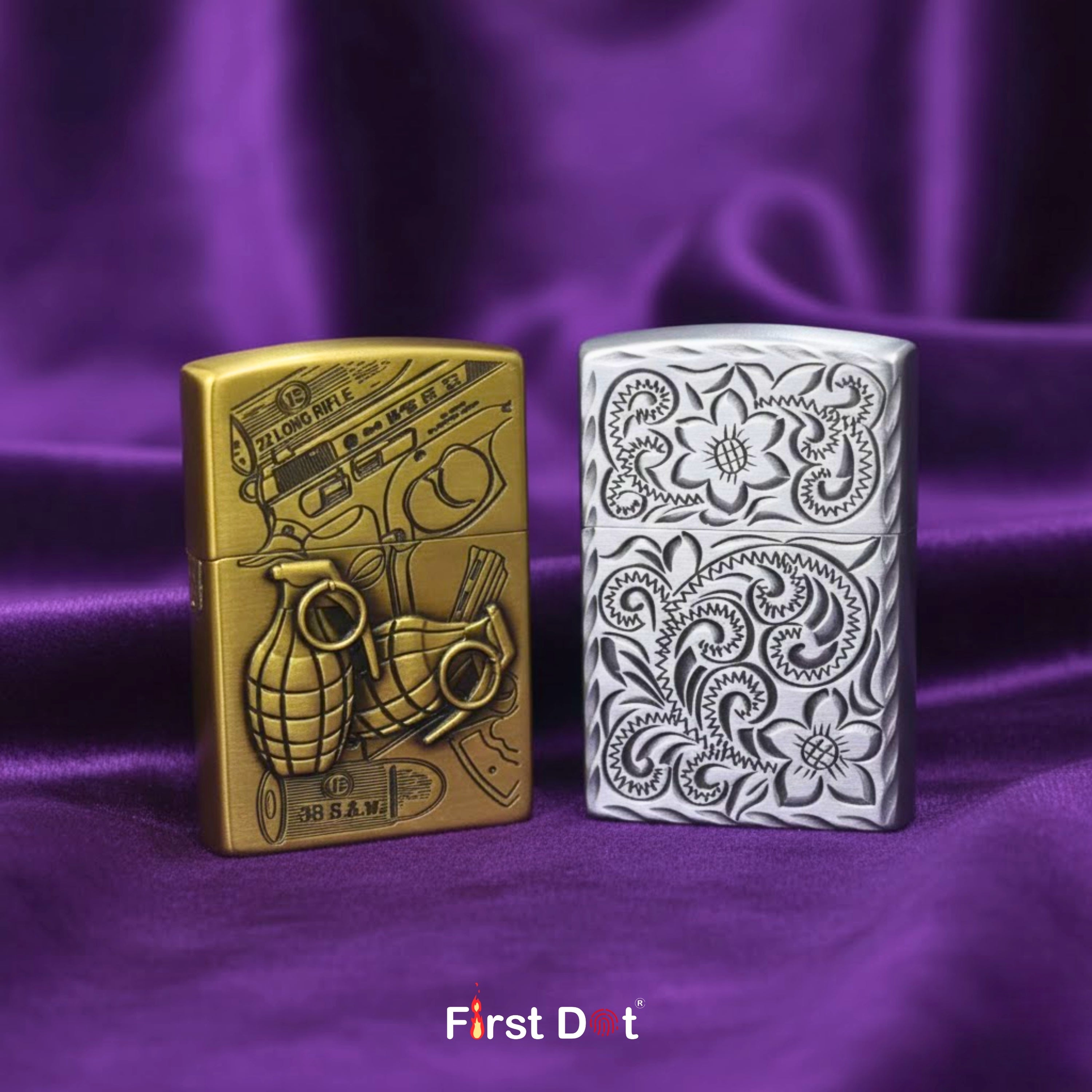 Two zippo lighters, one gold and one silver with intricate designs, on a purple fabric background. First Dot brand visible.
