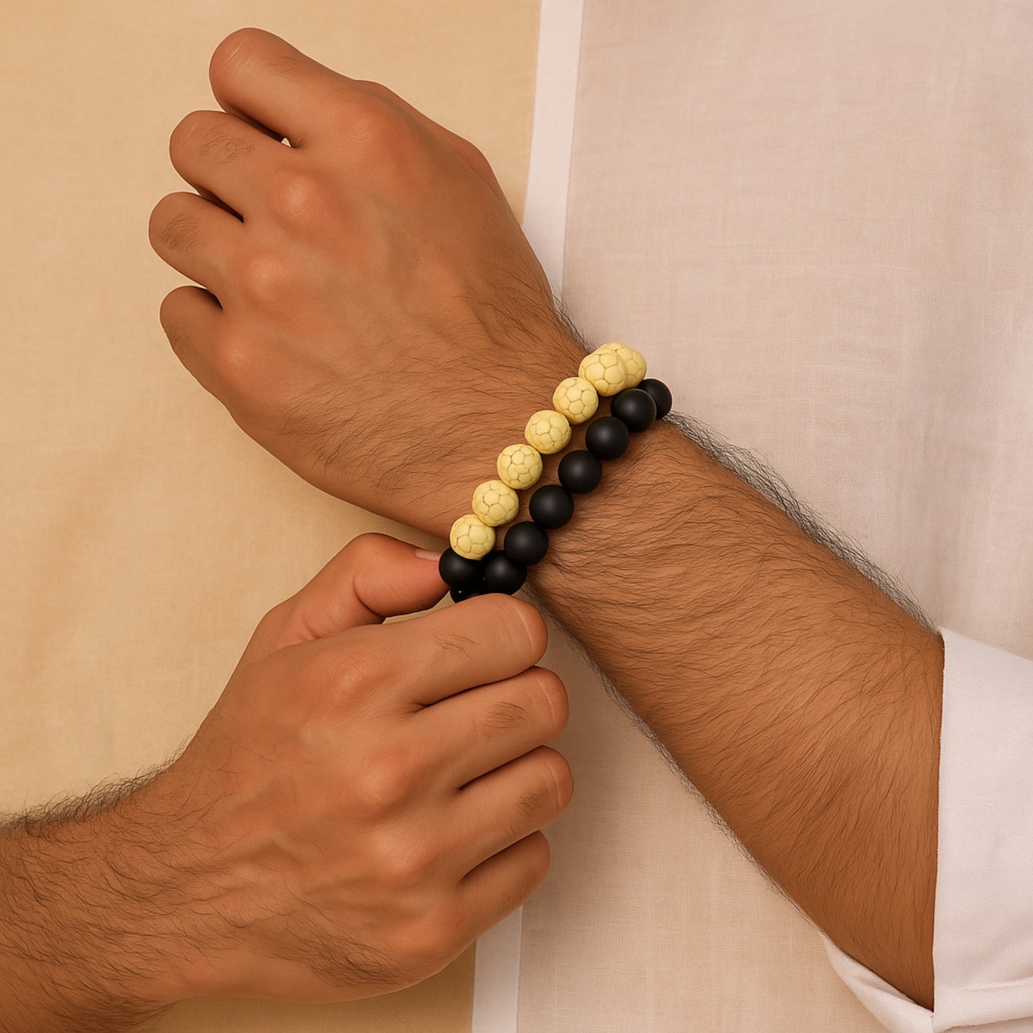 Hand wearing a black and yellow beaded bracelet against a beige  CrackleStoneBraceletbackground