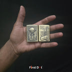Two gold lighters held in a hand against a dark background, with 'First Dot' branding.