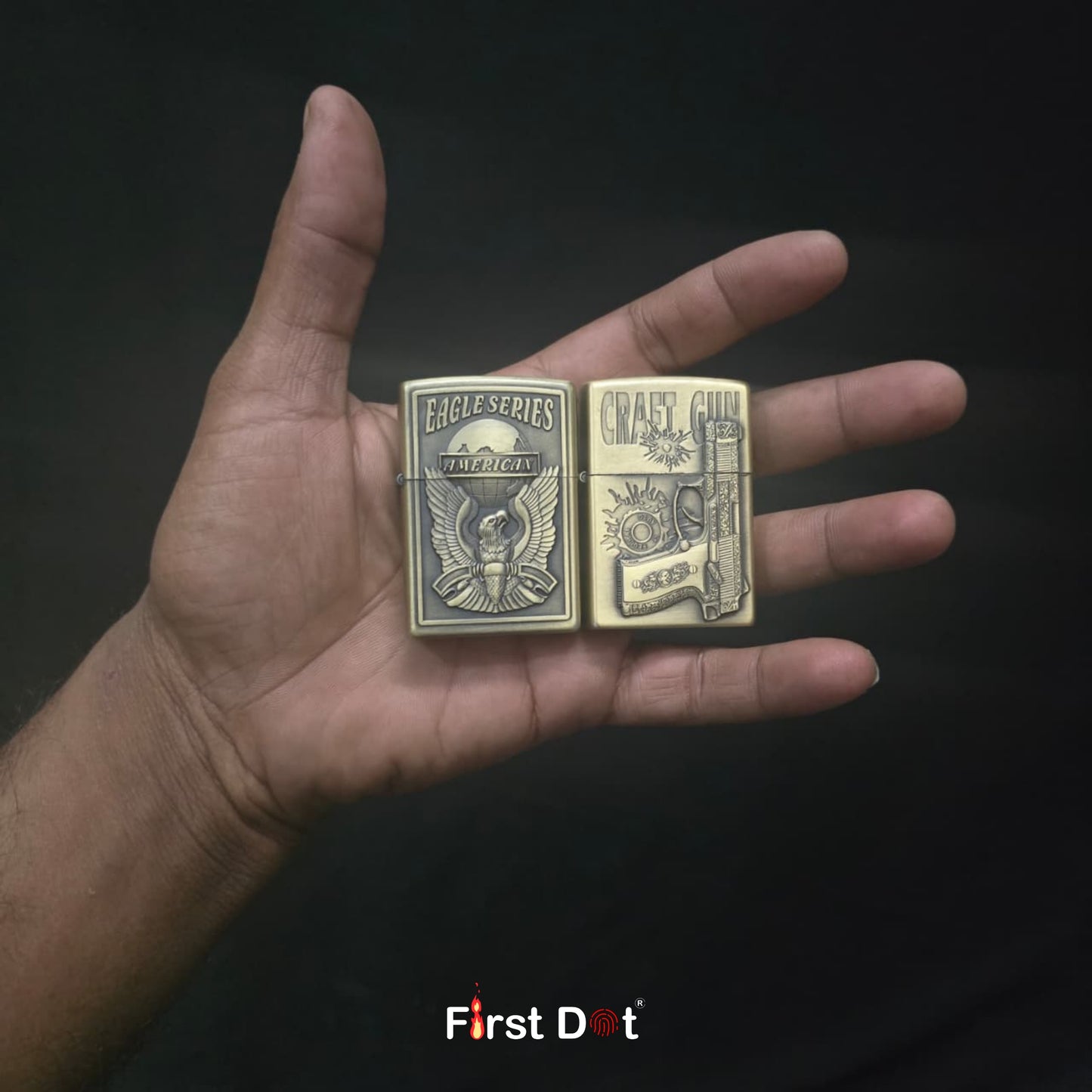 Two gold lighters held in a hand against a dark background, with 'First Dot' branding.