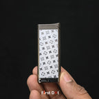 Lighter with a patterned cover held by a hand against a black background