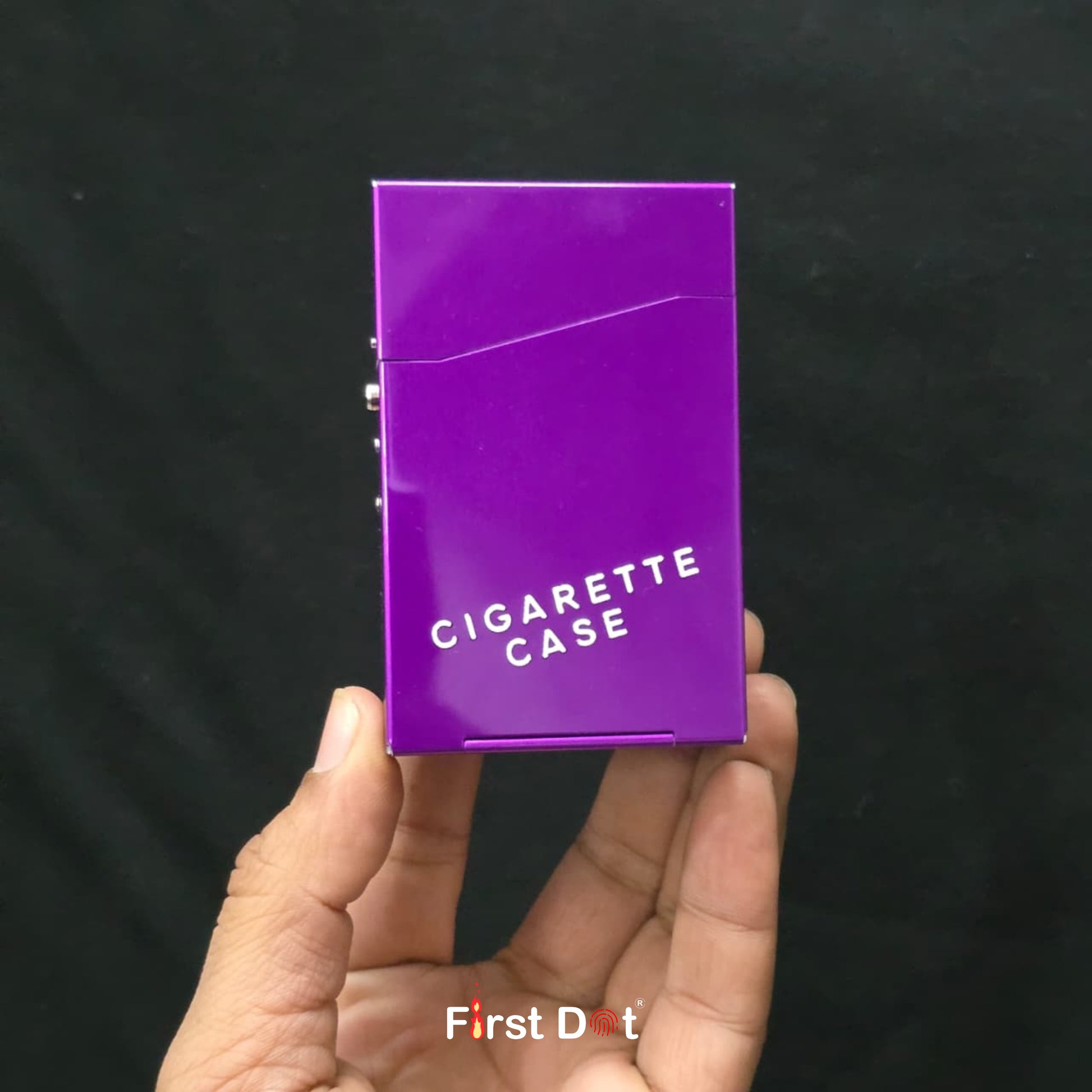 Purple cigarette case held in a hand against a black background