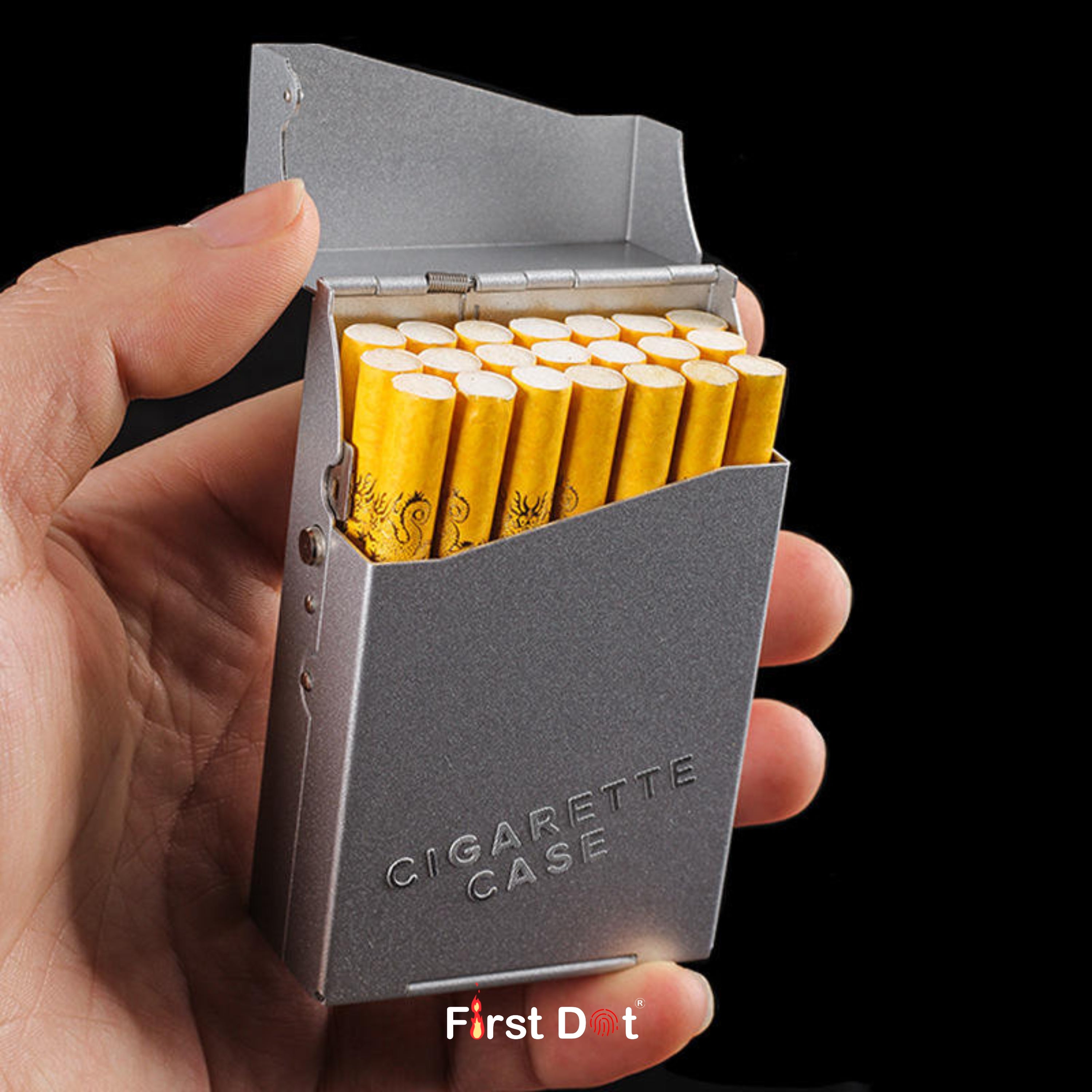 Hand holding a gray cigarette case with yellow cigarettes on a black background