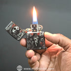 Hand holding a zippo lighter with a design on a dark background