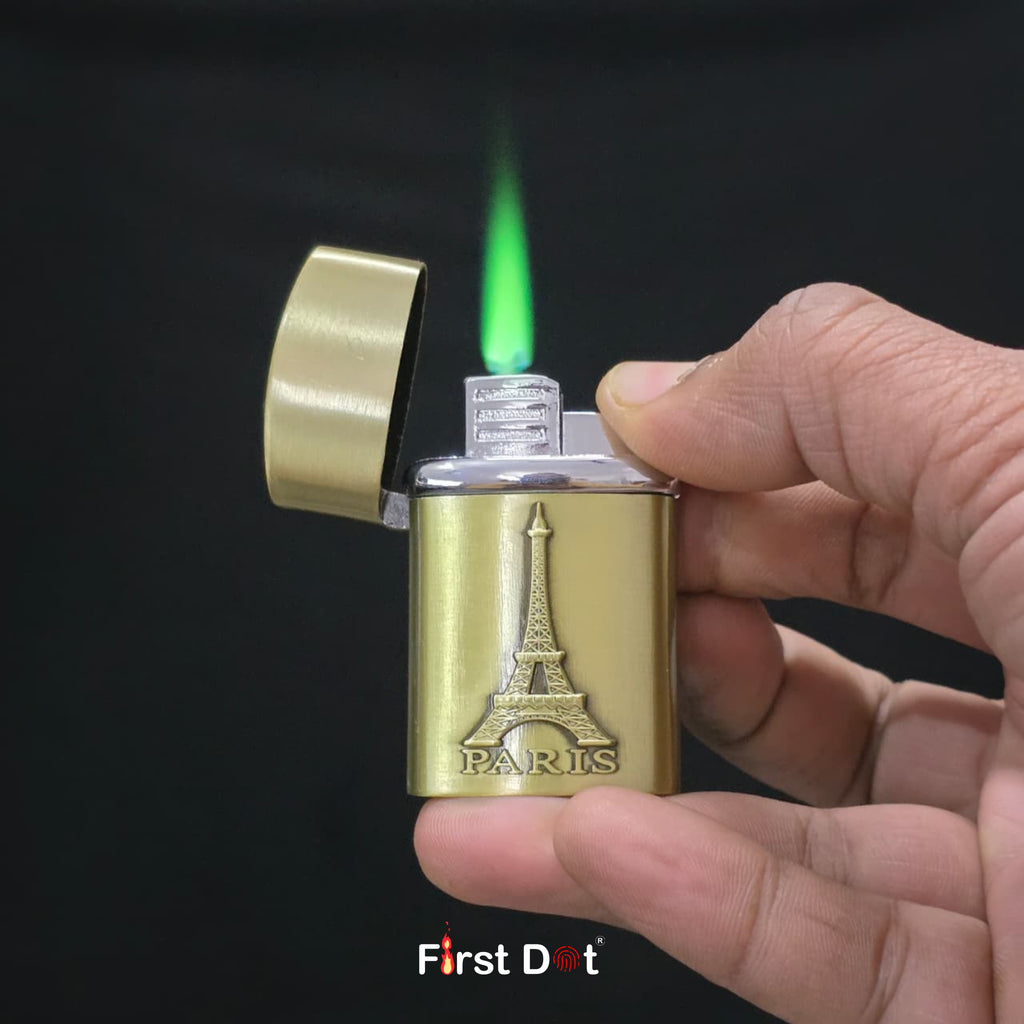 Gold lighter with Eiffel Tower design being lit against a black background, featuring 'First Dot' branding.