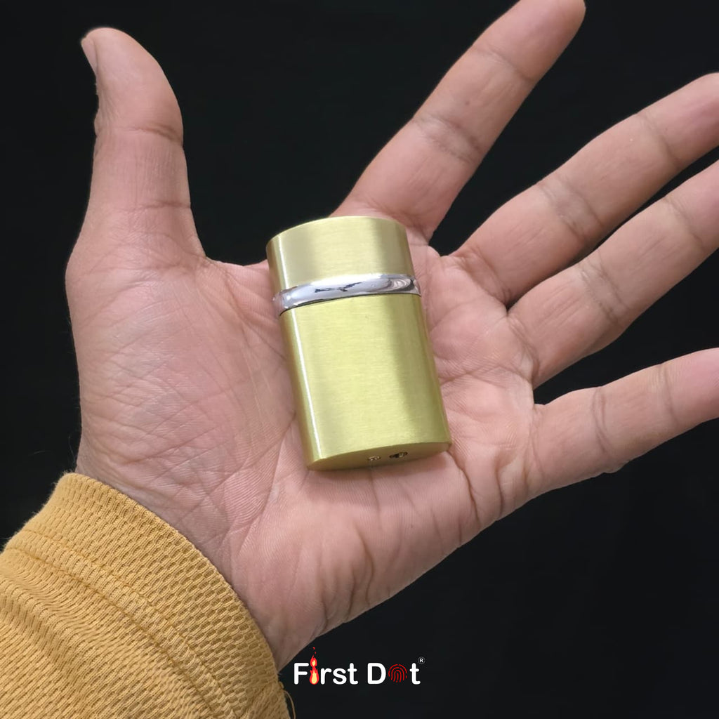 Gold cylindrical lighter held in a hand with 'First Dot' branding.