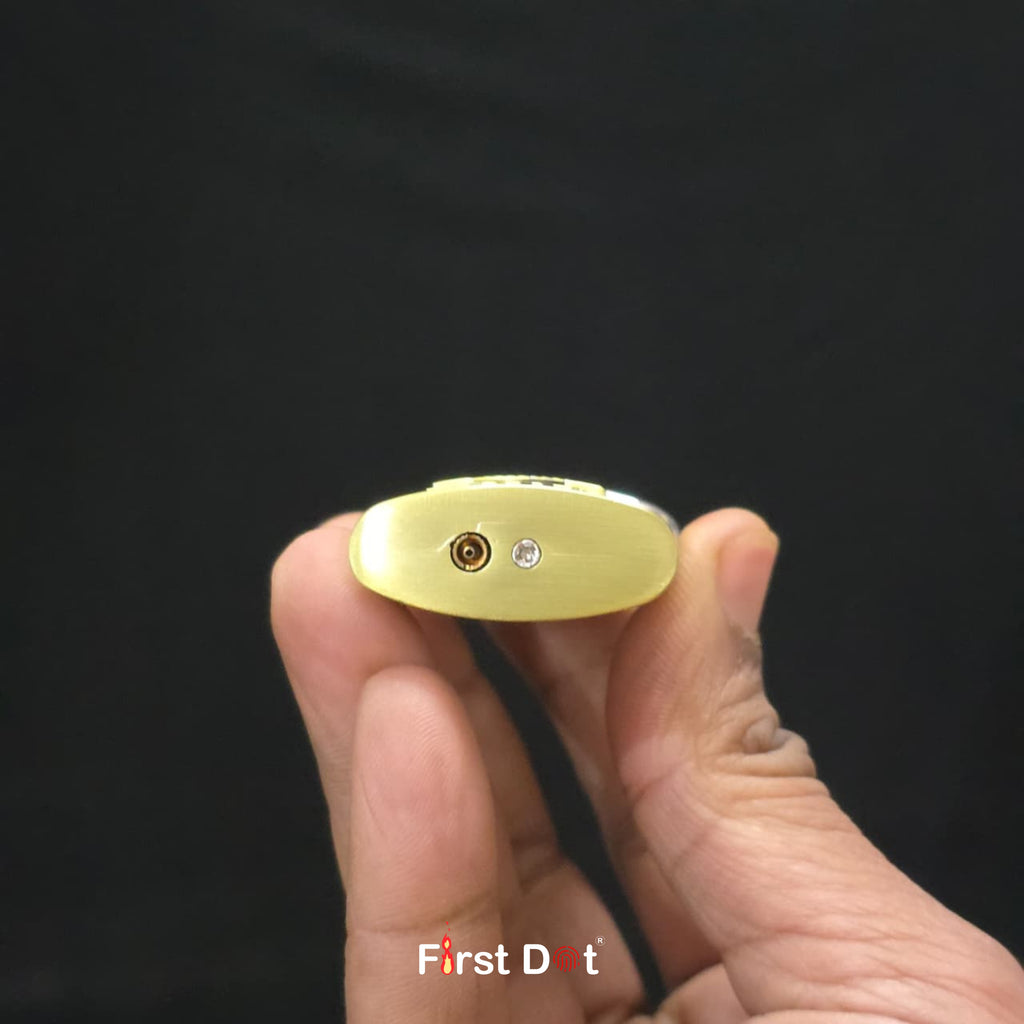 Gold lighter held in a hand against a black background