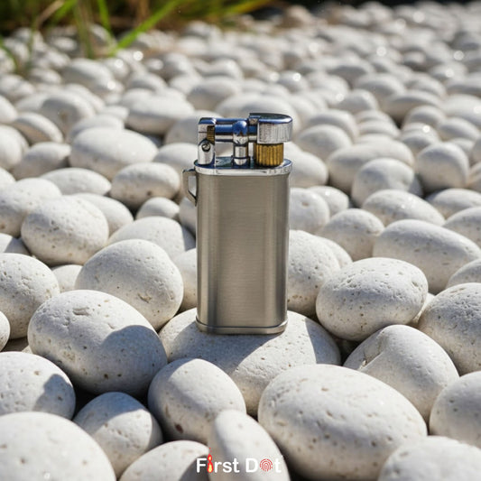 Metal lighter on pebbles with 'First Dot' branding