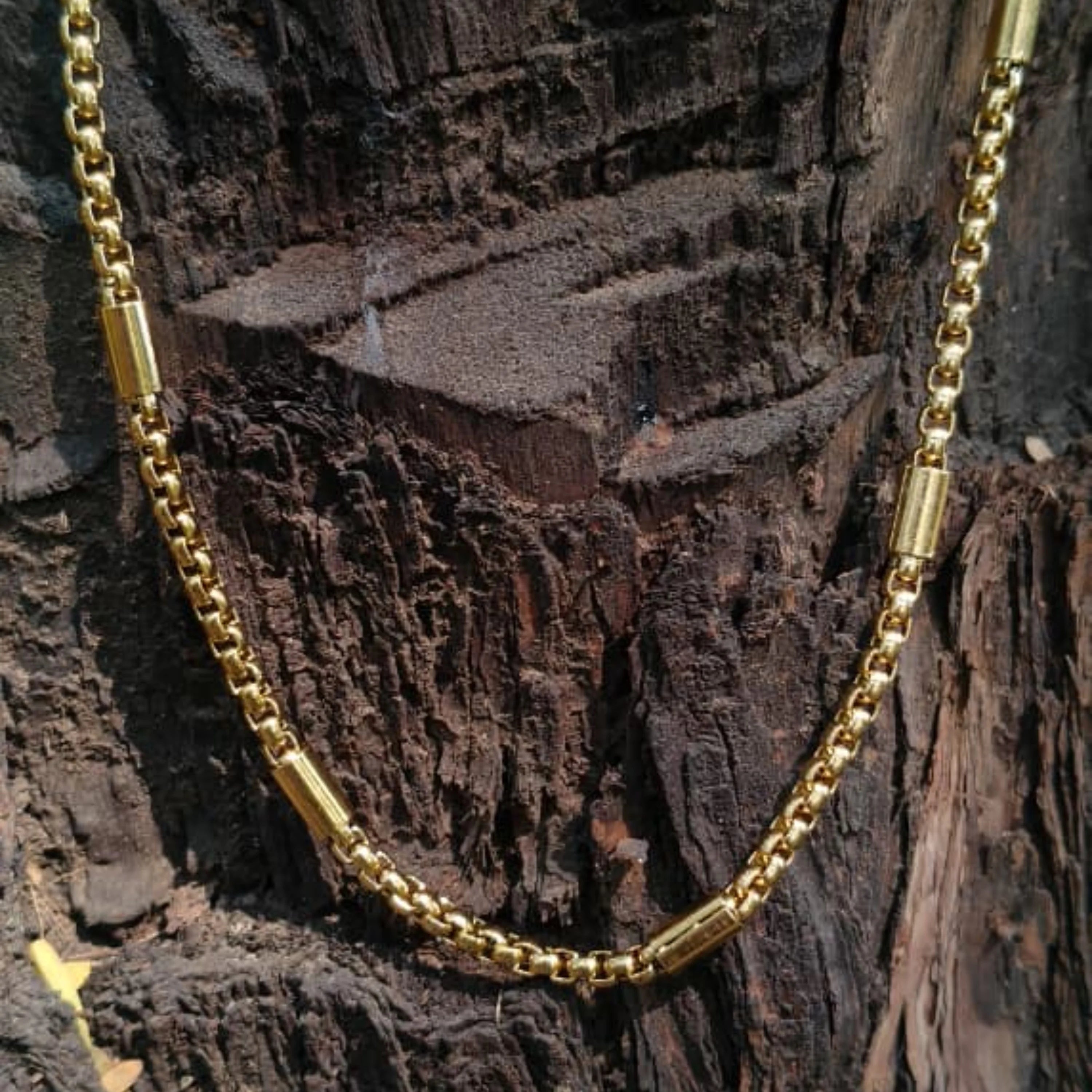 Gold chain necklace on a textured wooden surface First Dot Golden Ball Beaded Chain for Men 