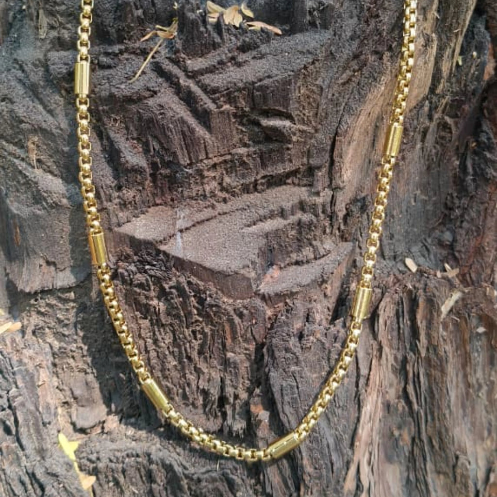 Gold chain necklace on a textured wooden surface First Dot Golden Ball Beaded Chain for Men 