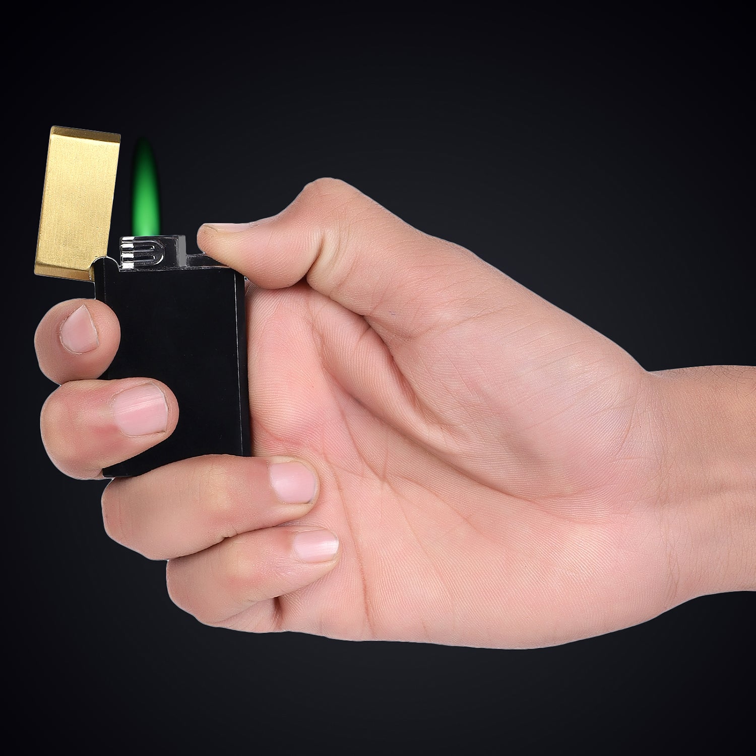 Hand holding a black lighter with a gold and green accent against a black background