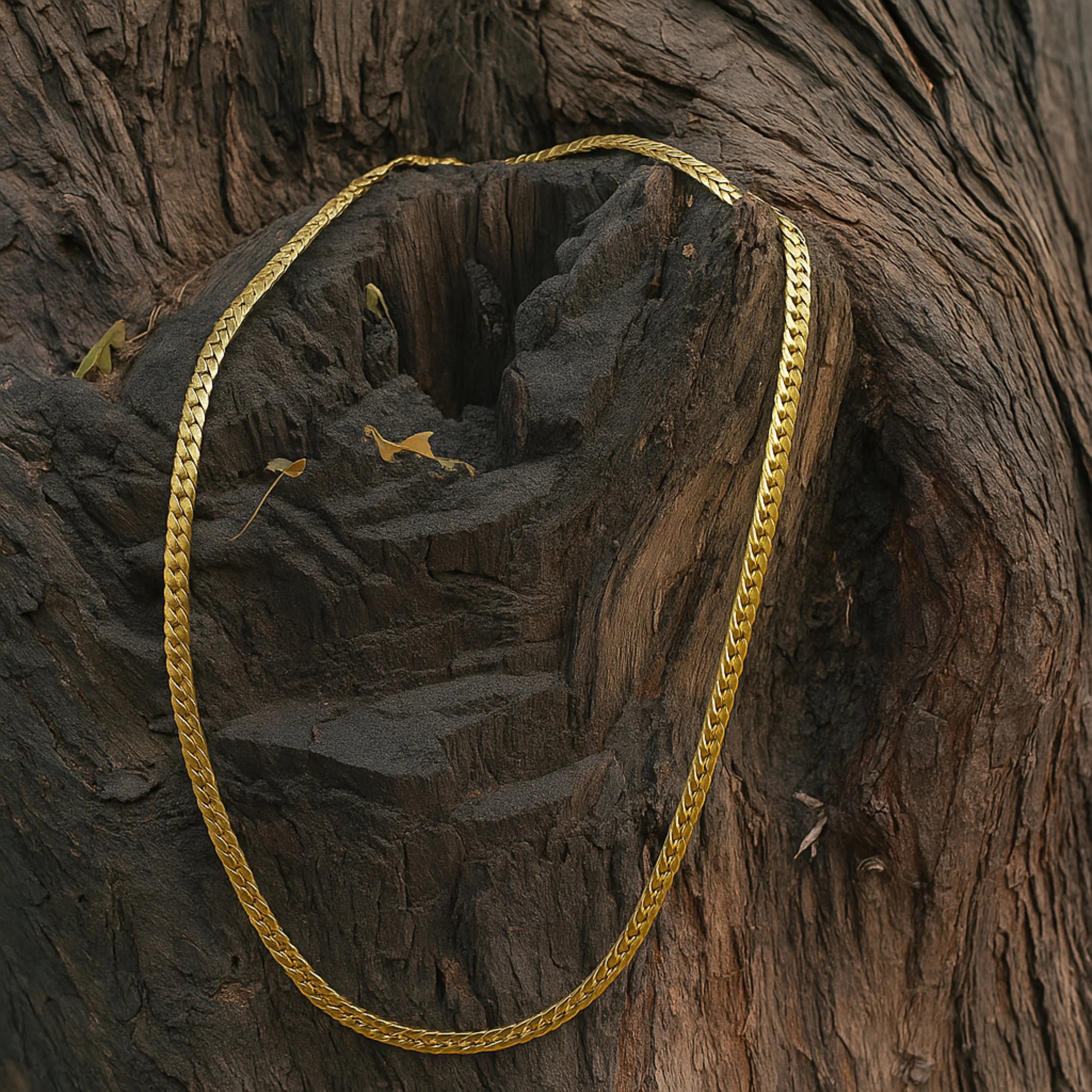 Gold chain draped over a textured wooden surface First Dot Italian Golden Curb Chain for Men