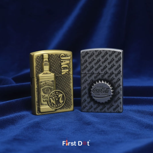 Two lighters, one gold and one silver, on a blue fabric background with 'First Dot' branding.