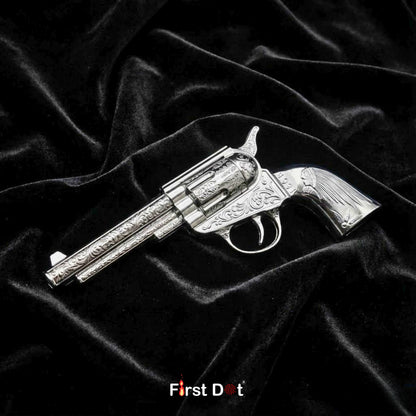 Silver revolver-shaped object on black velvet fabric with 'First Dot' branding. Mini Antique Revolver Gun Lighter – Jet Flame Windproof | First Dot