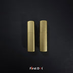 Two gold lighters on a black textured background with 'First Dot' branding.