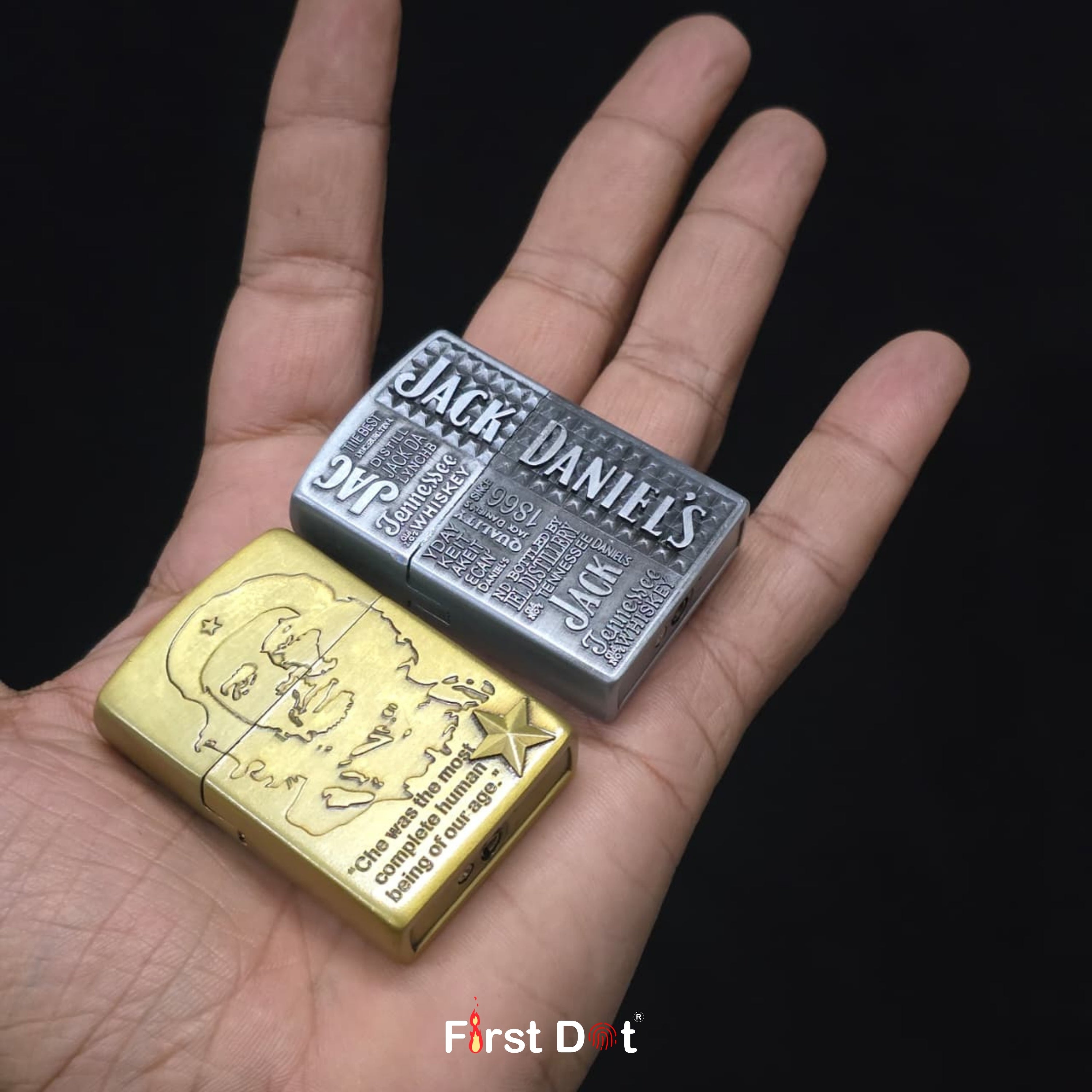 Two Jack Daniel's lighters, one gold and one silver, held in a hand against a black background.