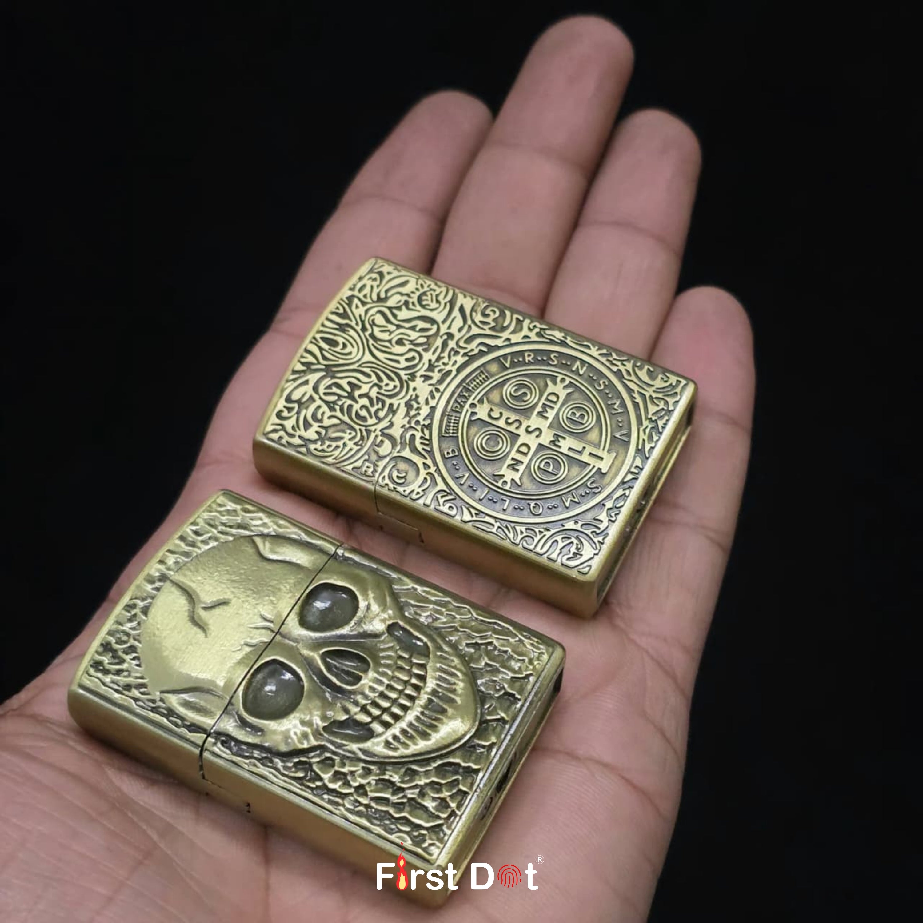 Two ornate gold lighters held in a hand against a black background, with 'First Dot' branding.