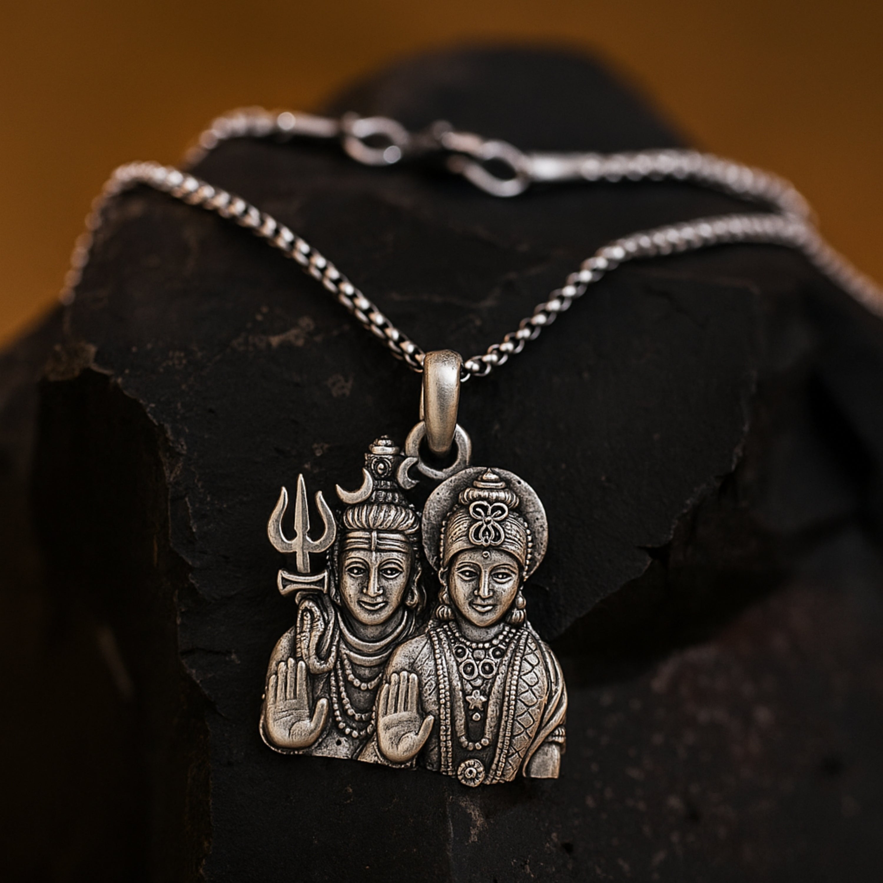 Silver pendant with two figures on a dark stone surface ShivaParvati LocketwithChain