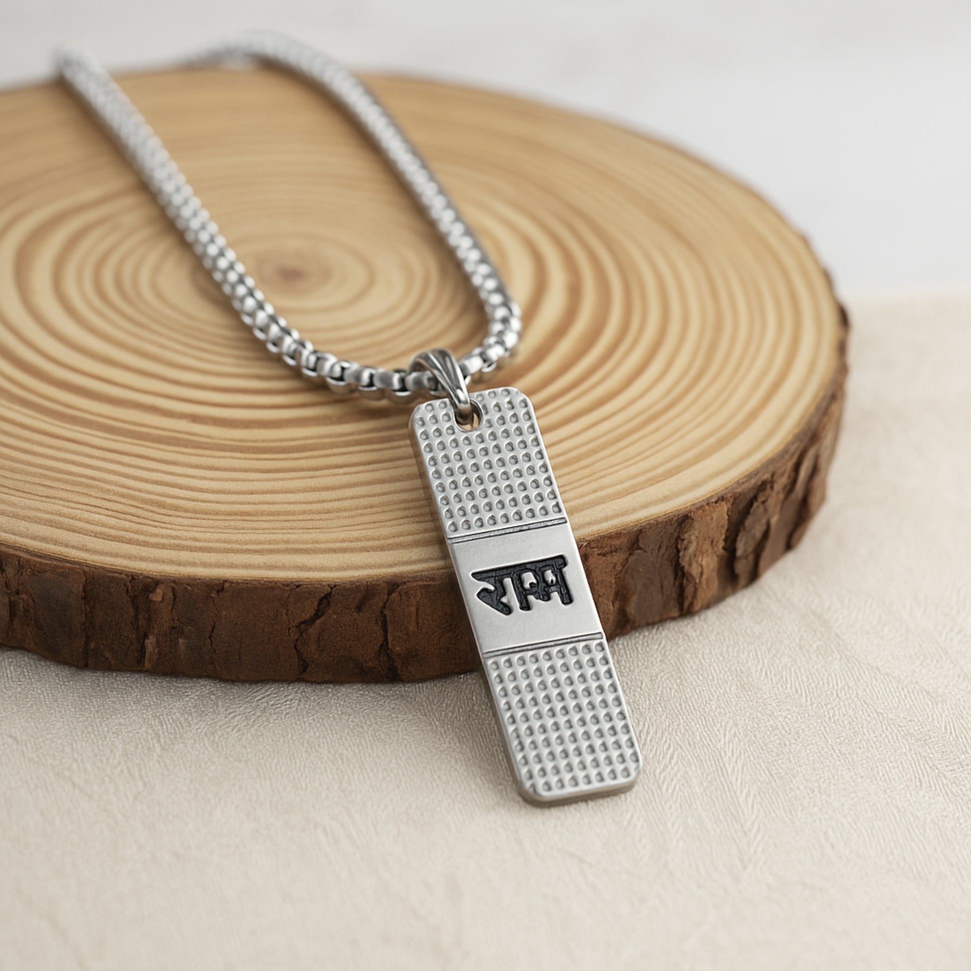 Silver necklace with a pendant on a wooden surface ShriRam NaamPendantLocketwithChain
