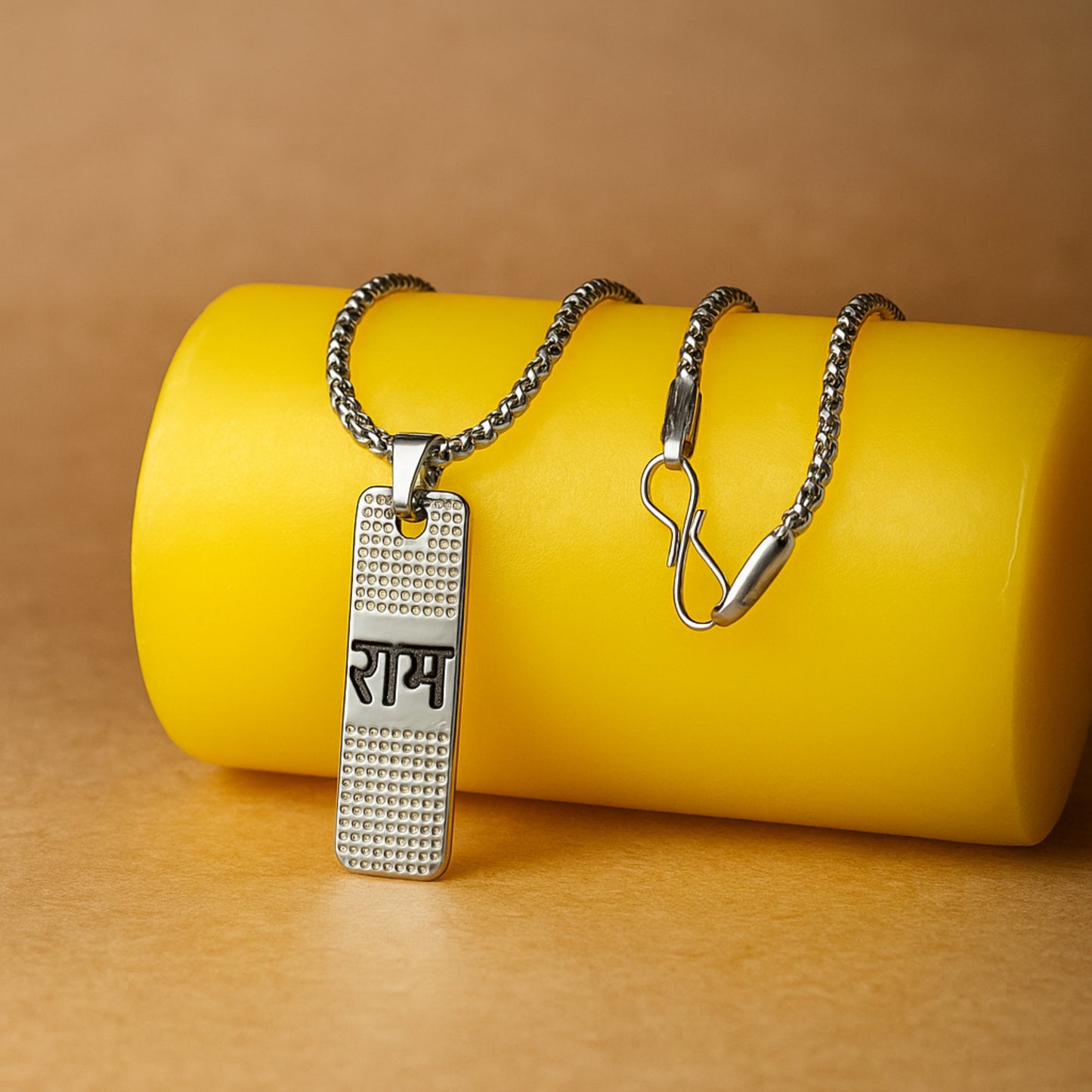 Silver necklace with a pendant on a yellow cylindrical object against a beige background Silver necklace with a pendant on a wooden surface ShriRam NaamPendantLocketwithChain