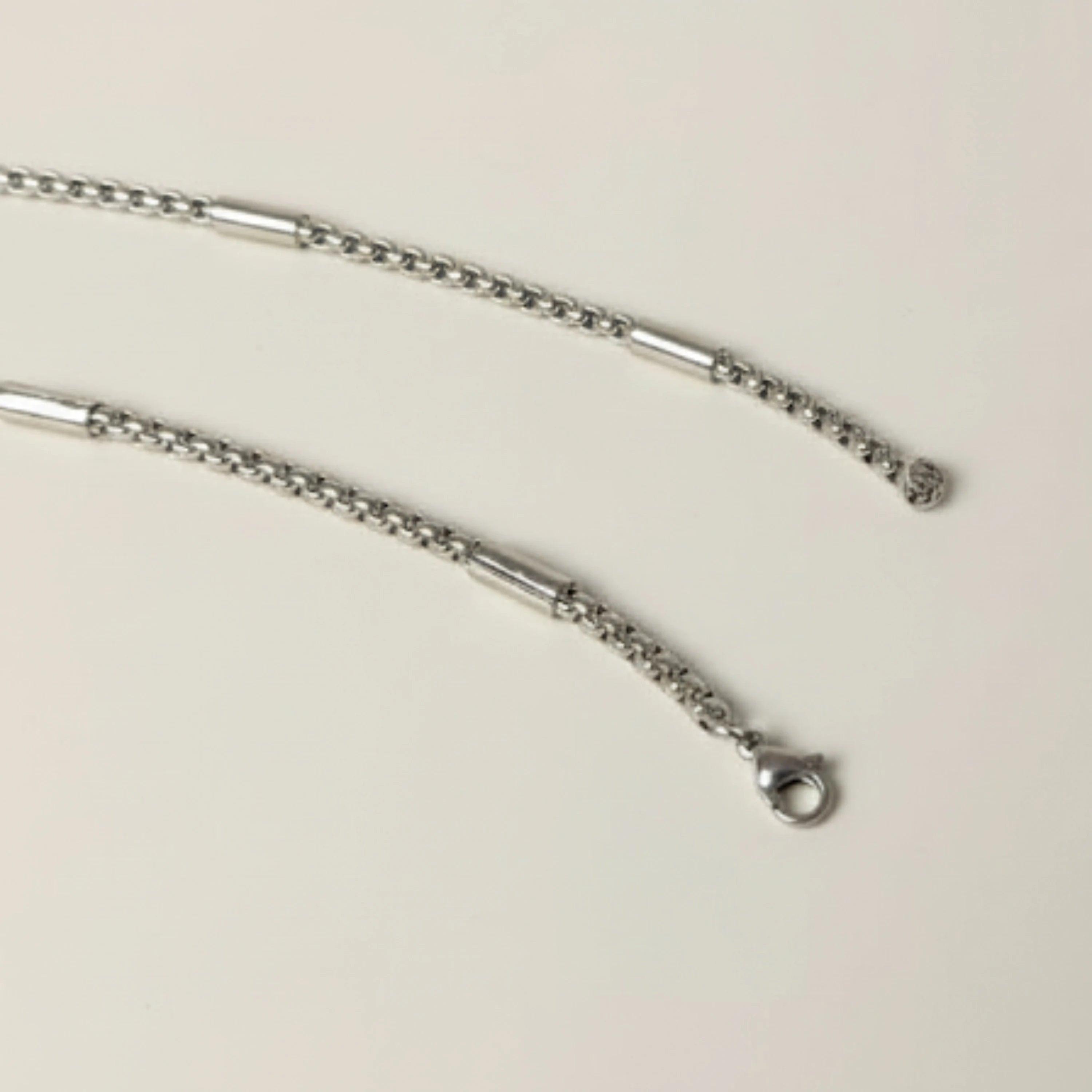 Silver chain necklace on a beige background First Dot Silver Ball Beaded Chain for Men