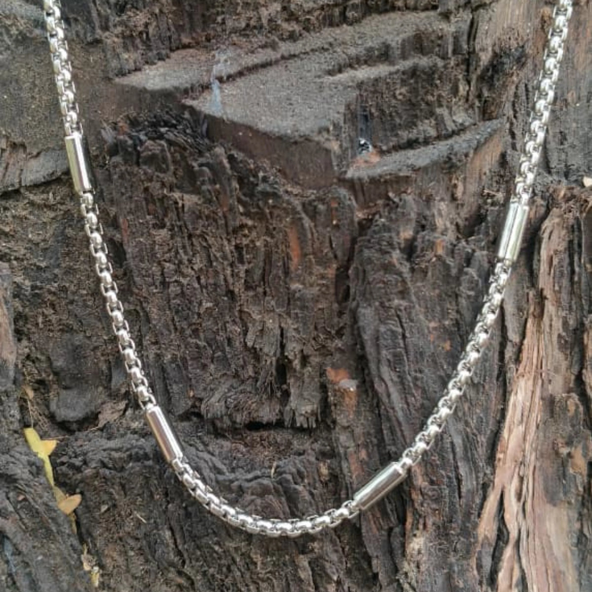 Silver chain necklace on a textured wooden surface First Dot Silver Ball Beaded Chain for Men