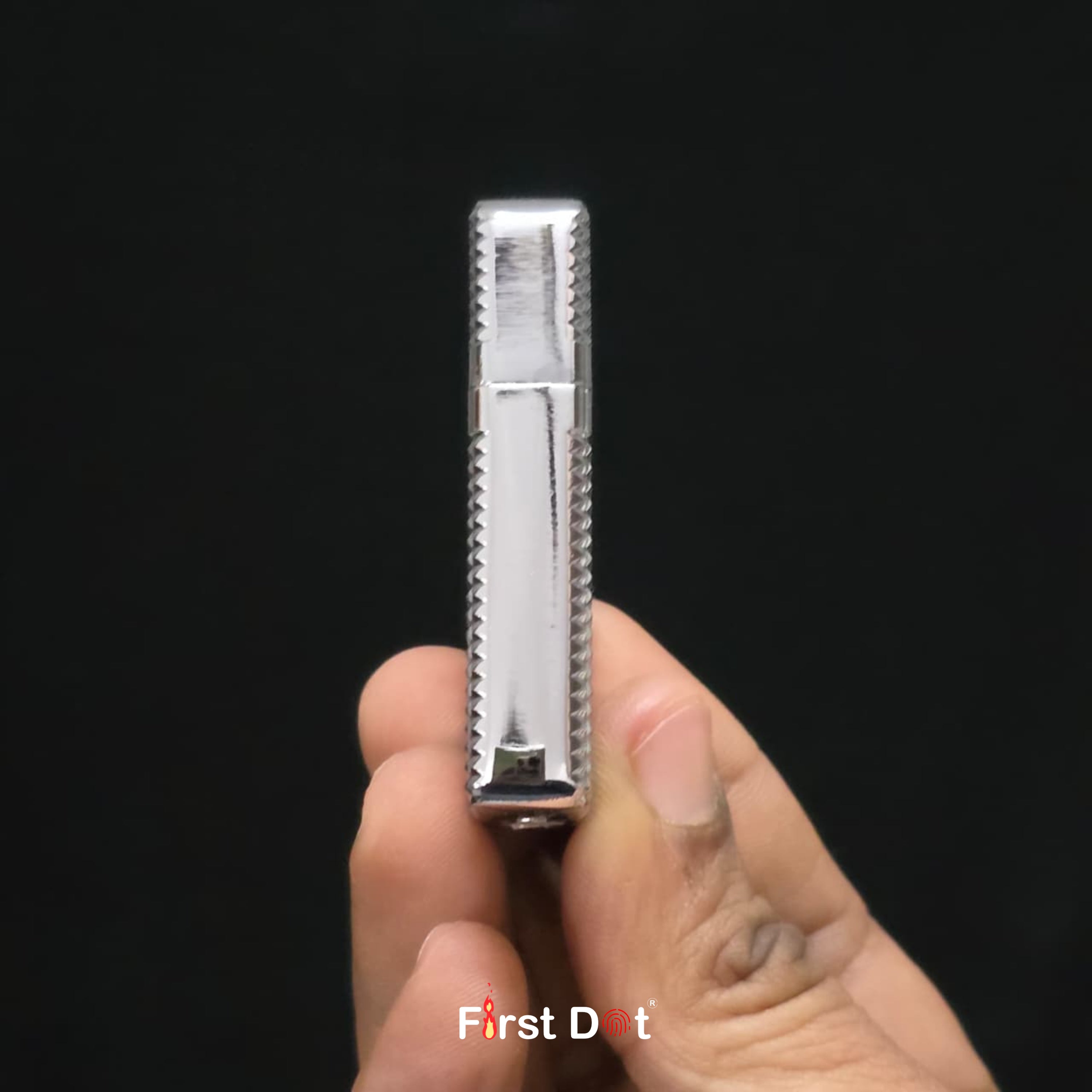 Hand holding a metallic Diamond cut lighter against a black background with 'First Dot' branding.