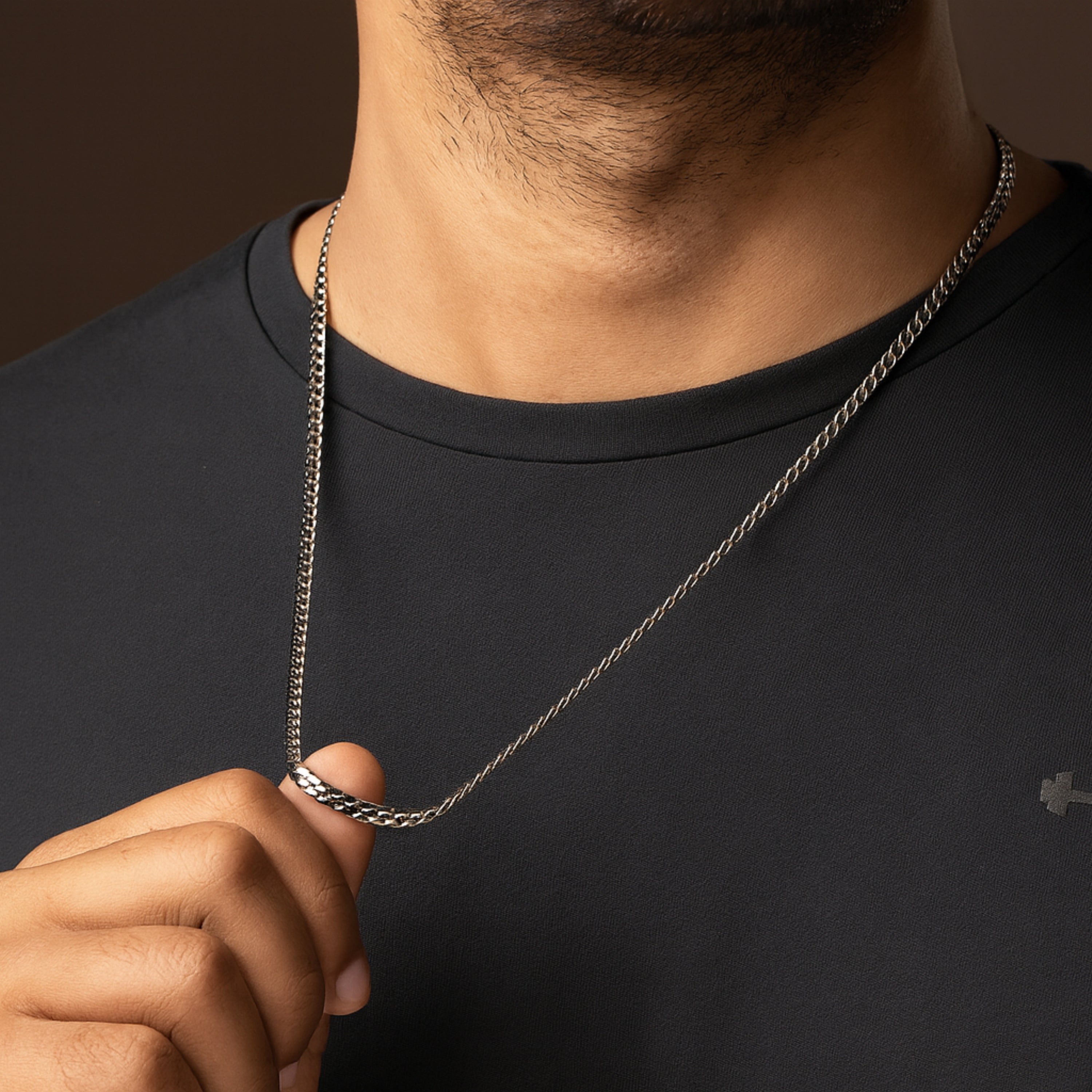 Man wearing a black shirt with a silver chain necklace