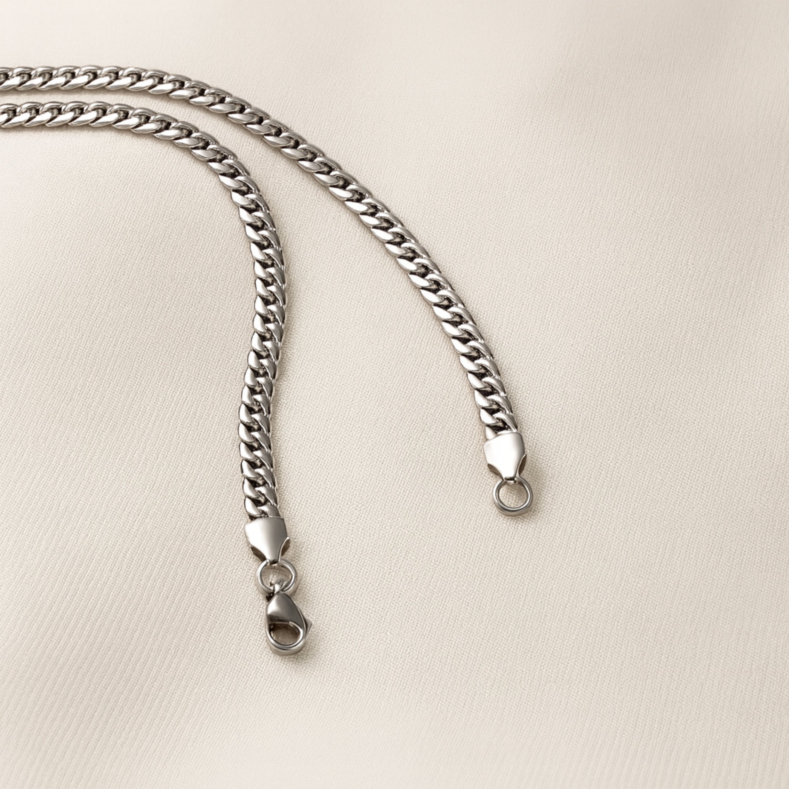 Silver chain necklace on a beige background