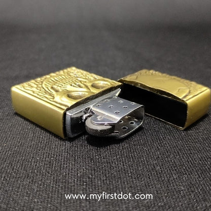 Gold lighter with intricate design on a dark background
