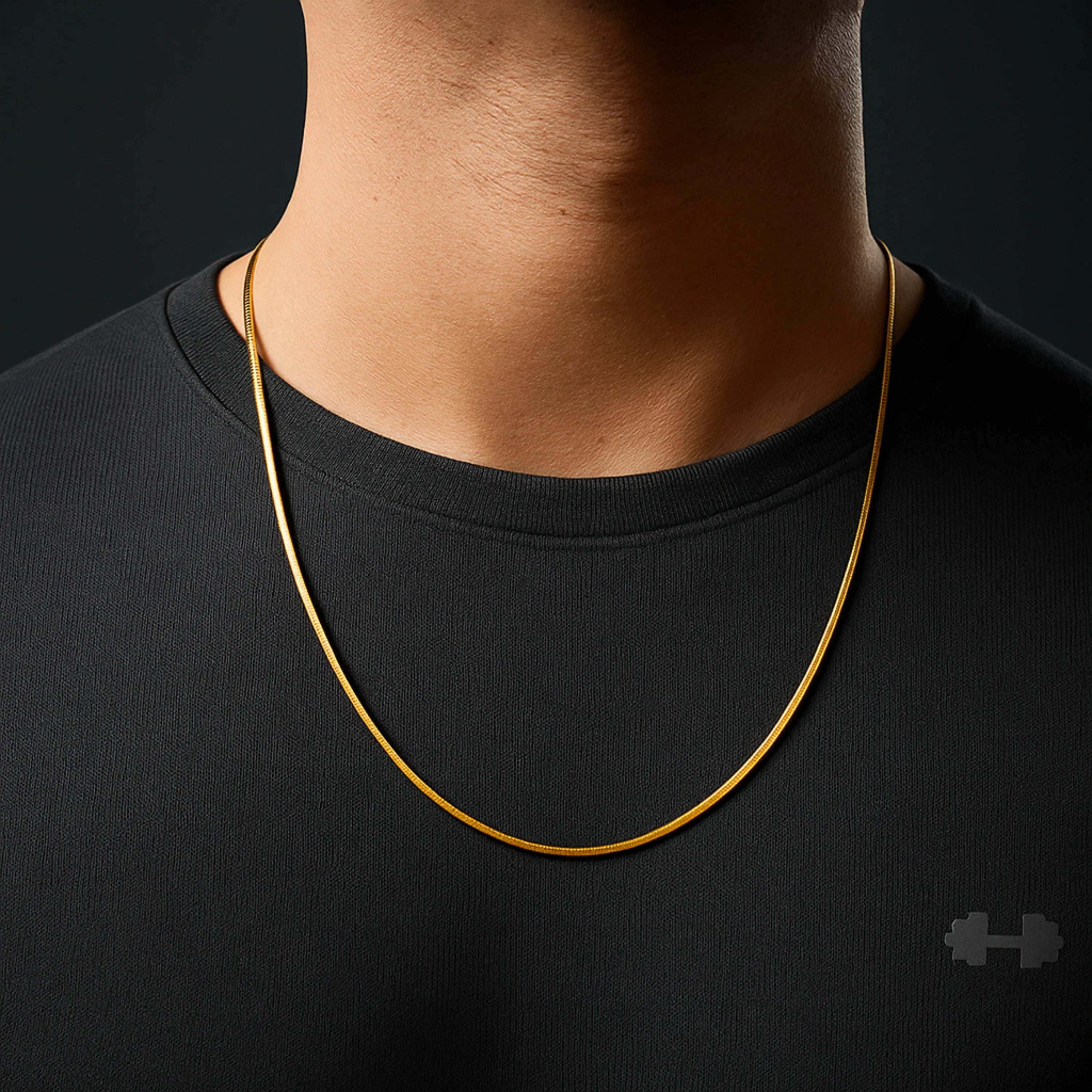 Person wearing a gold necklace against a black background nakeChainNecklace