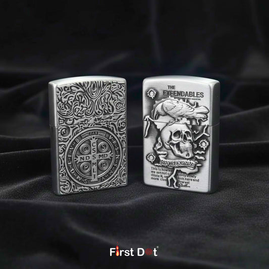 Two silver lighters with intricate designs on a dark fabric background, featuring the brand 'First Dot'.