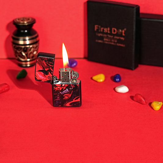 Lighter with flame on a red surface, surrounded by decorative stones and a black box labeled 'First Dot'. Hannya Demon Premium Refillable Cigarette Lighter