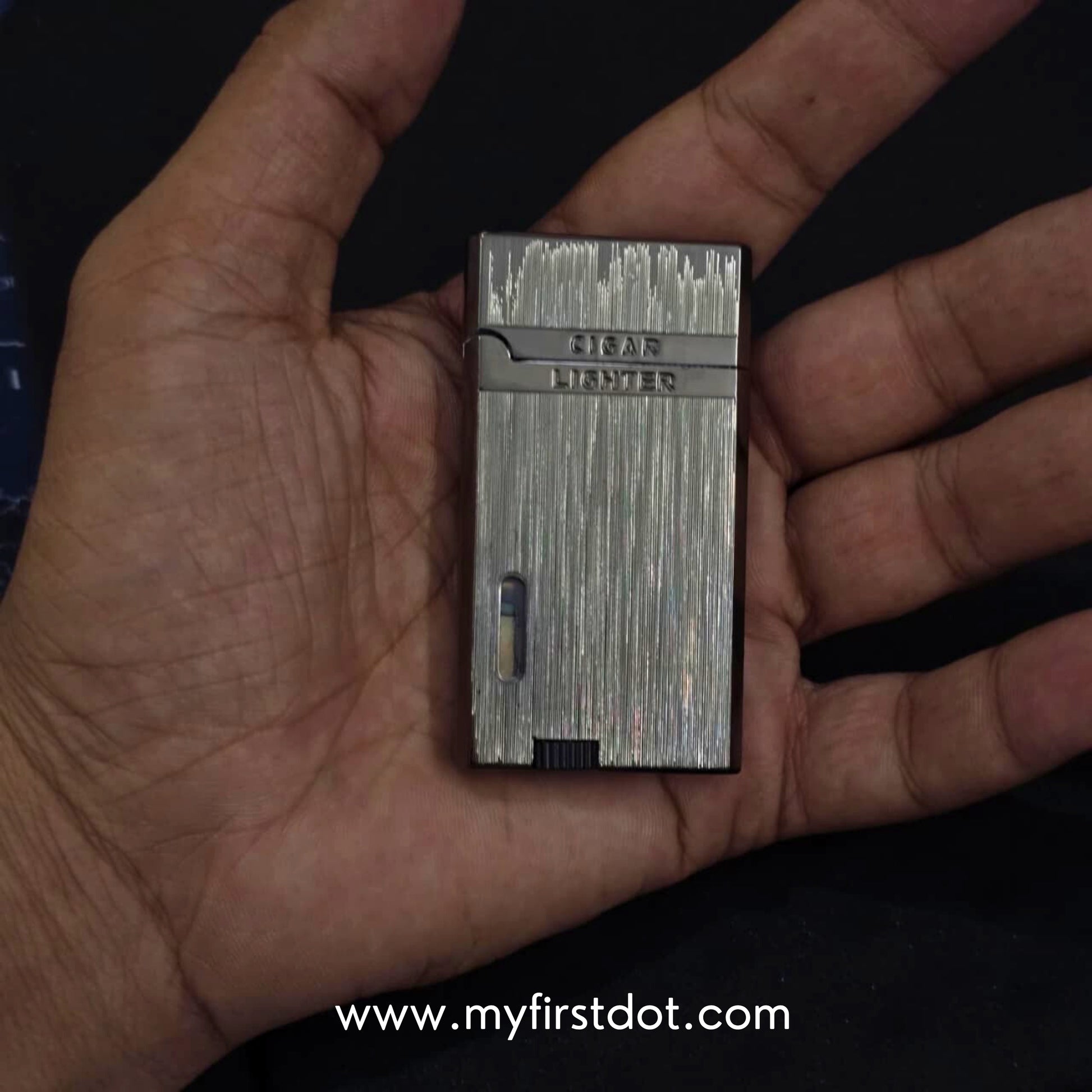 Small metallic lighter held in a hand with a dark backgroundMonarch Double Flame Torch Lighter Brushed Grey