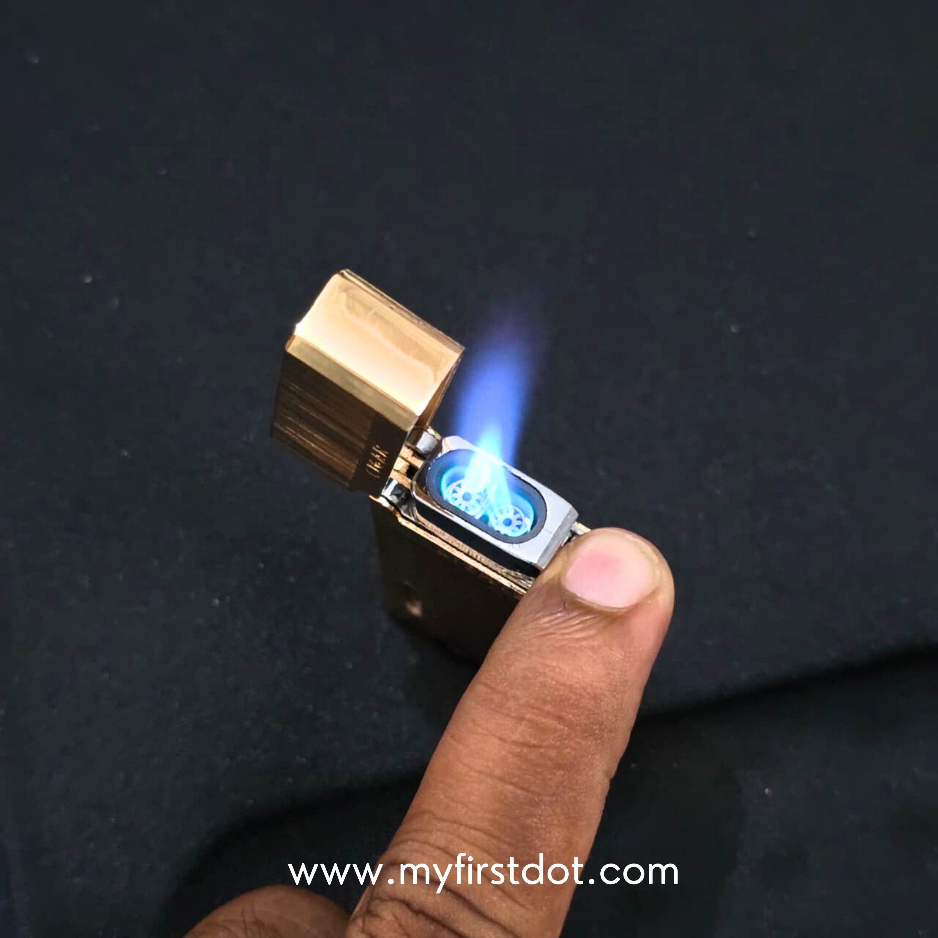 Hand holding a gold lighter with blue flame against a dark background Monarch Double Flame Torch Lighter Metallic Gold
