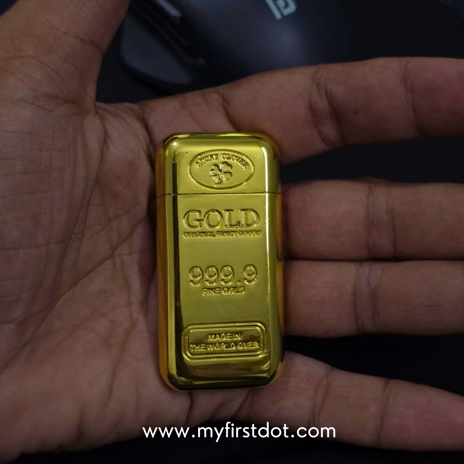Gold bar held in a hand with a visible brand logo in the background first dot Premium Gold Bar Jet Flame Lighter  999.9 Engraved Windproof Flame