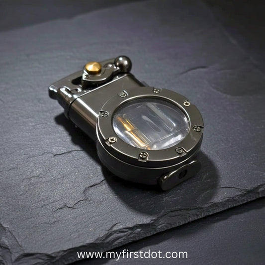 Metallic lighter with magnifying glass on a dark surface, brand 'myfirstdot' visible. first dot Vintage Trench Retro Rocker Lighter | Dual Flame Lighter